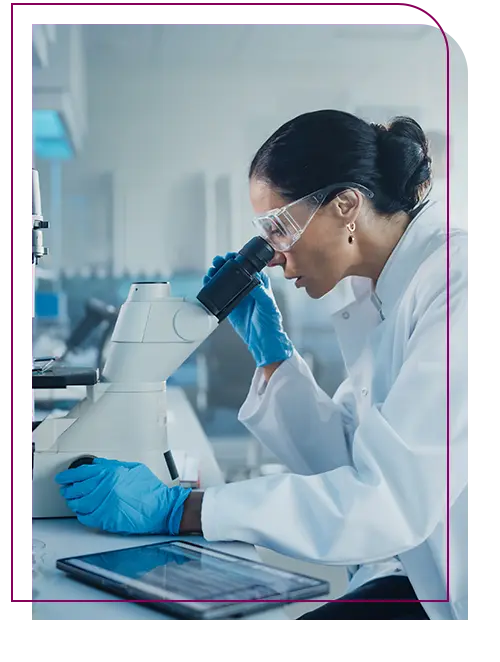 biomedica olhando o microscopio no laboratorio