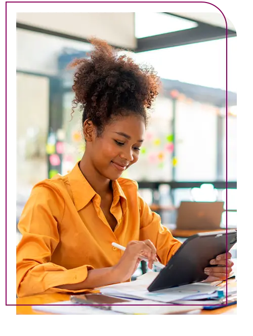 mulher negra com cabelo preso trabalhando em notebook