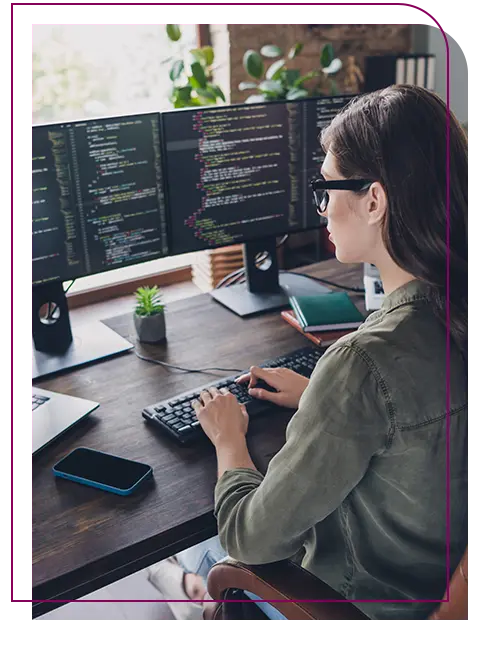 mulher trabalhando para sistemas para internet, na frente de 2 telas de computador