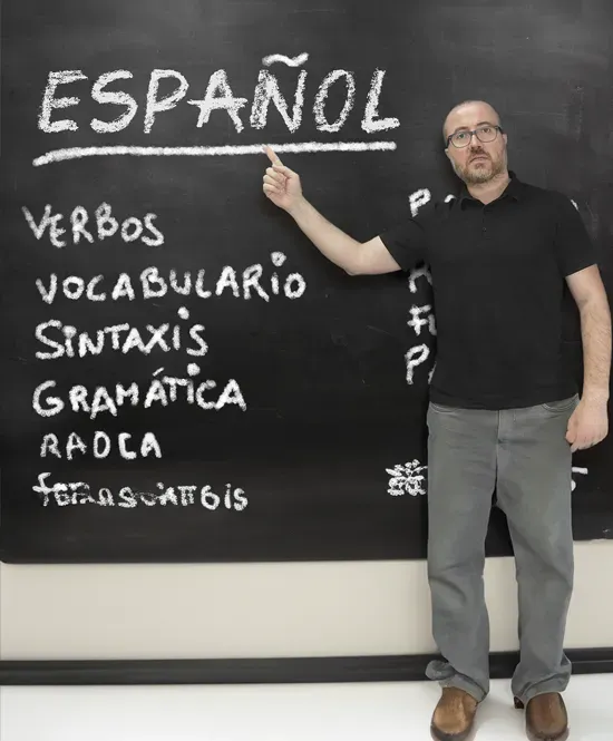 Professor e quadro negro ao fundo
