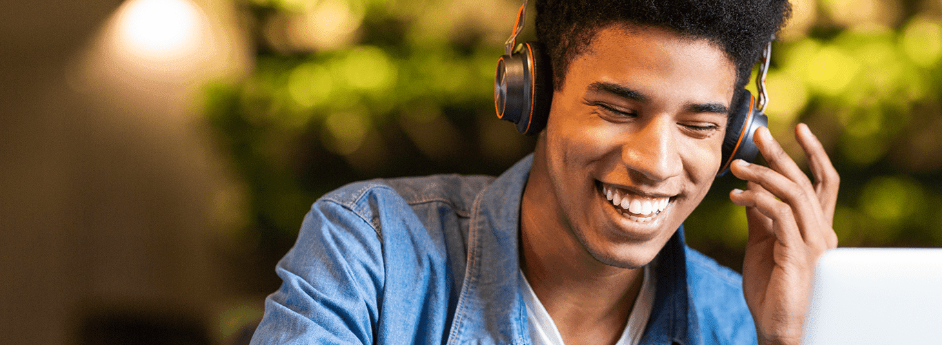 rapaz escutando podcast com seu fone sorrindo