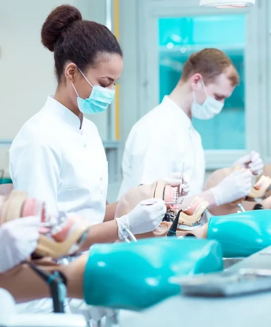 uma mulher e um homem dentistas com roupas brancas e máscaras e luvas manuseando instrumentos de odontologia