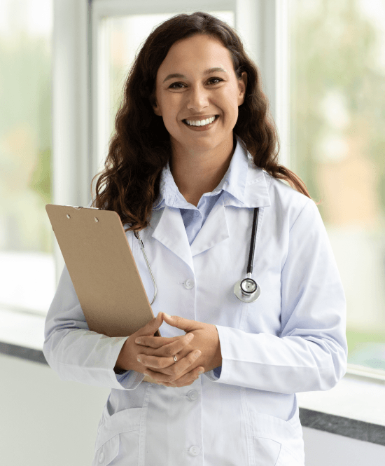 Médica sorrindo segurando prancheta