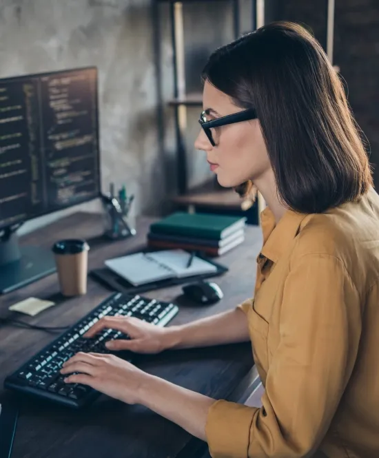mulher cientista da computação de óculos analisando dados em um monitor de computador