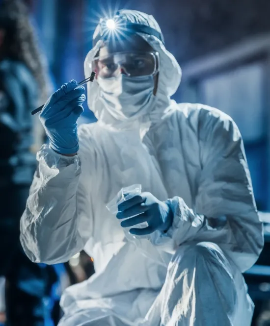 pessoa investigadora forense com luva máscara e roupa de proteção investigando materiais
