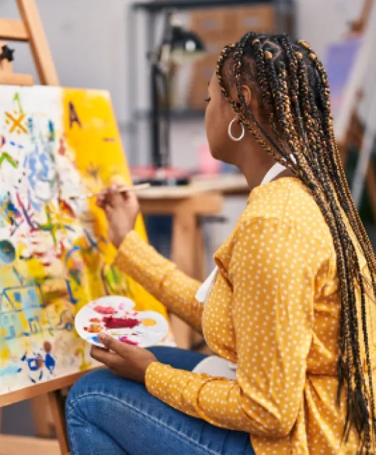 Mulher de tranças pintando uma tela