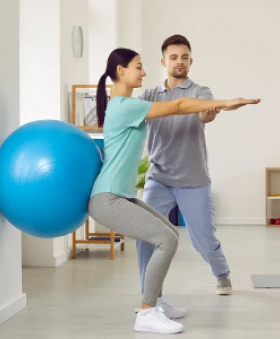 Fisioterapeuta cuida de paciente em exercício com bola