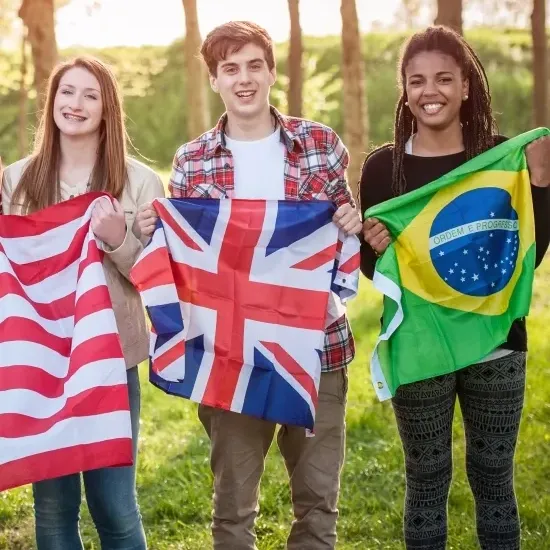 pessoas comas as bandeiras dos Estados Unidos, do Reino Unido e do Brasil