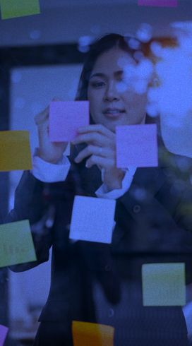 mulher organizando um board de vidro com postit