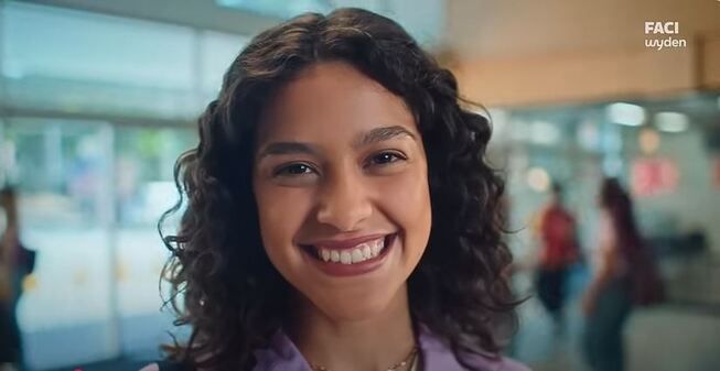 menina sorrindo com a logo da faci