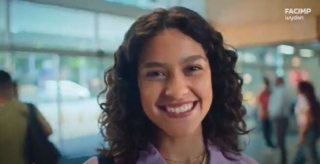 jovem sorrindo com o logo da facimp