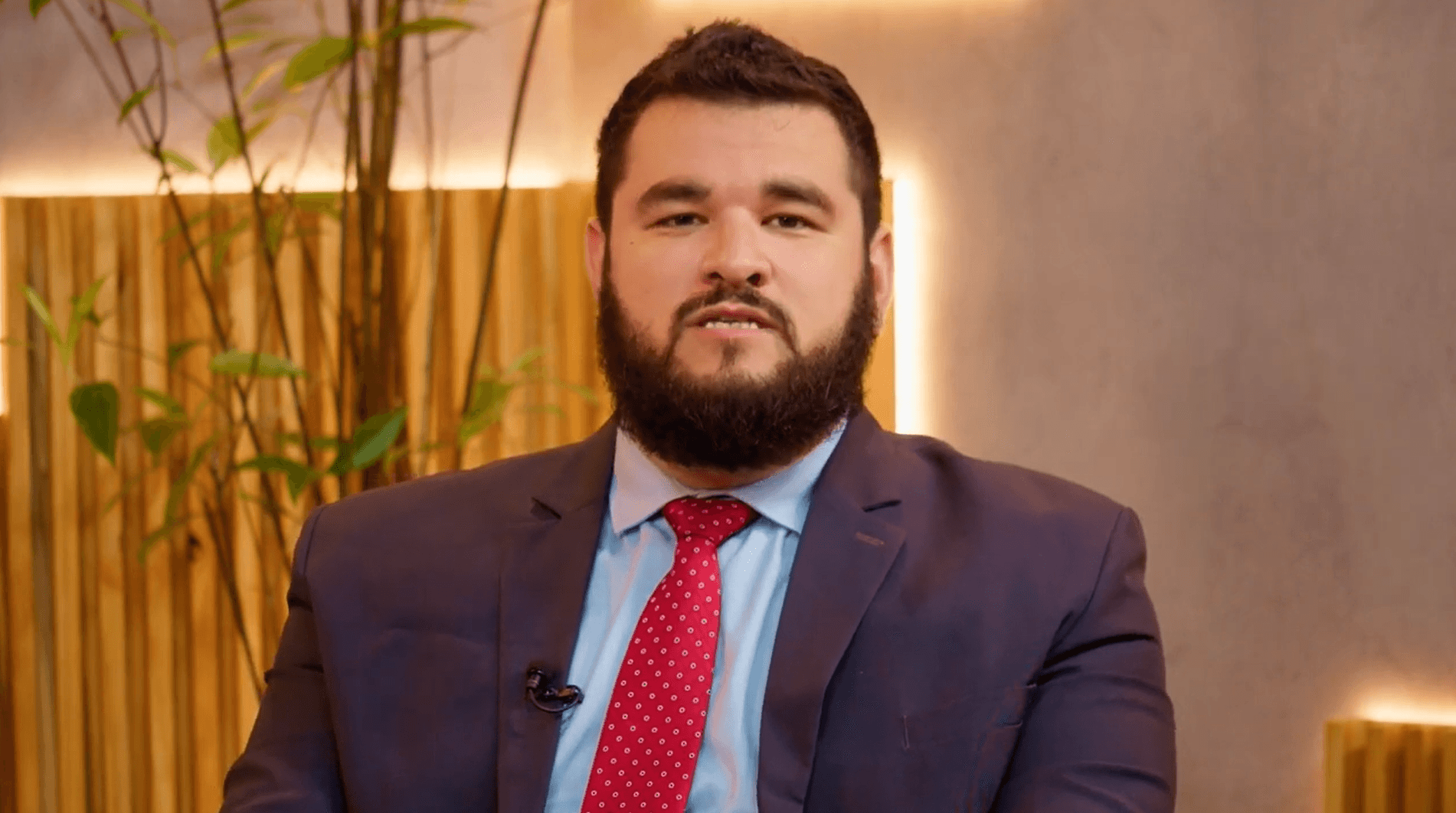 homem branco com barba e cabelos escuros usando terno e gravata