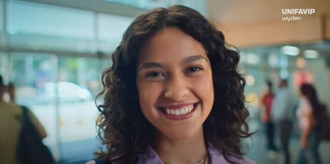 jovem sorrindo com logo da uniFavip