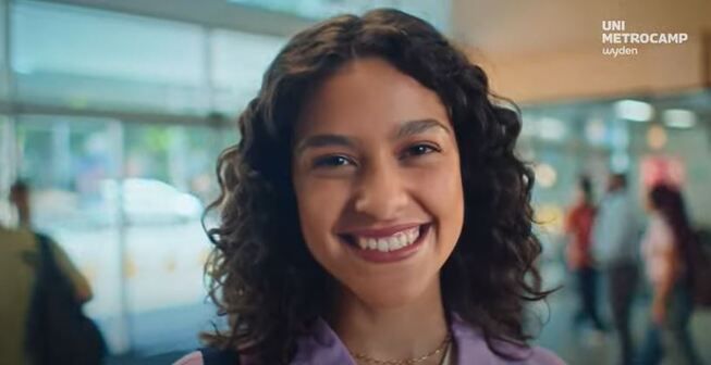 jovem sorrindo com a lofo unimetrocamp
