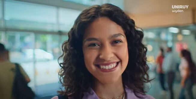 jovem sorrindo com a logo da uniruy